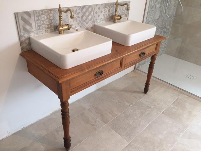 Salle de bain rénovée par Sindt : double vasque sur meuble bois et robinetterie laiton