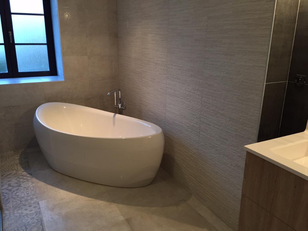 Baignoire îlot posée dans une salle de bain contemporaine